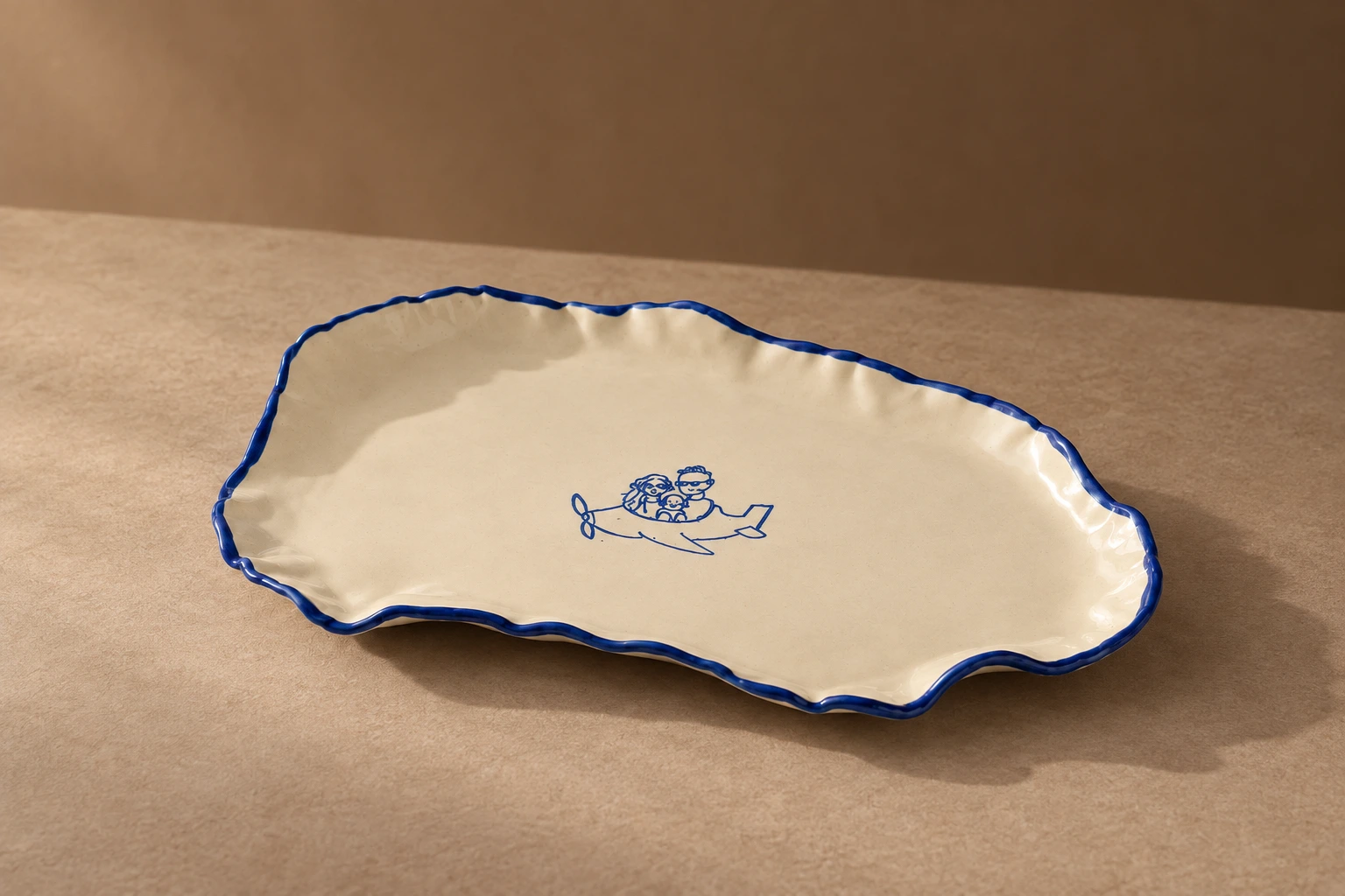 Cream platter with a wavy cobalt-blue rim and a small plane illustration