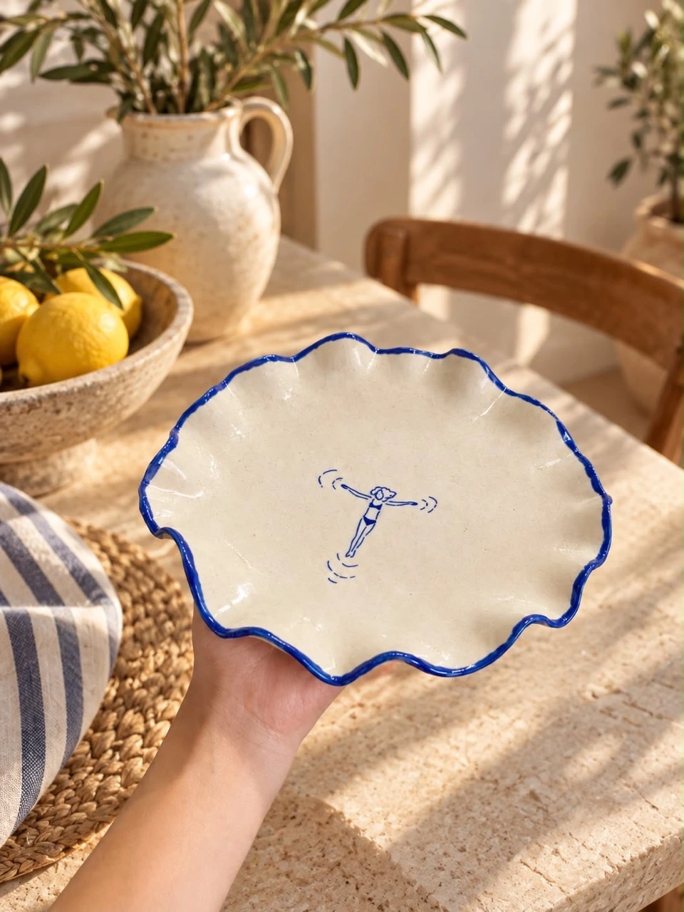 Clara’s scalloped blue-rim swimmer platter held in a hand
